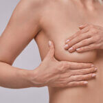 Žena si provádí samovyšetření prsu kvůli včasnému odhalení rakoviny prsu (karcinomu prsu).